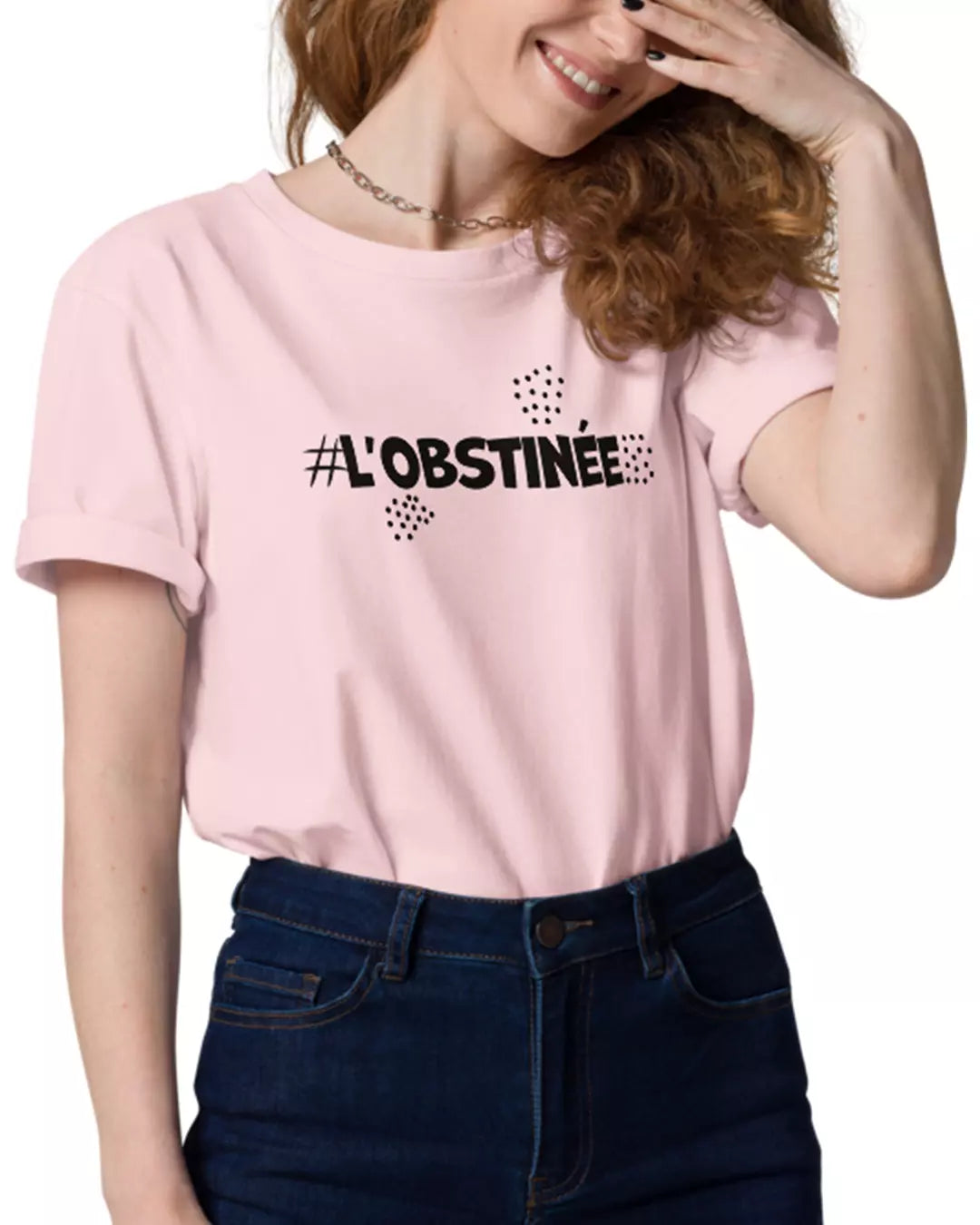 Une femme portant le t-shirt rose l'obstinée vu de face